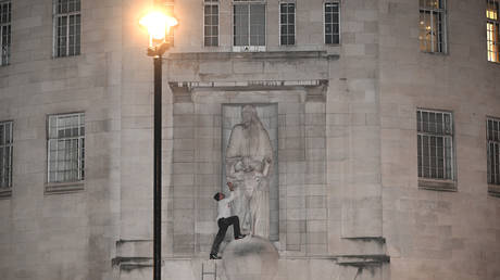 СМОТРЕТЬ мужчина взобрался на BBC, чтобы атаковать статую скандального художника — RT World News