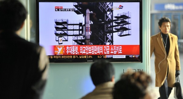 Туристы на железнодорожном вокзале в Сеуле смотрят новость о запуске ракеты