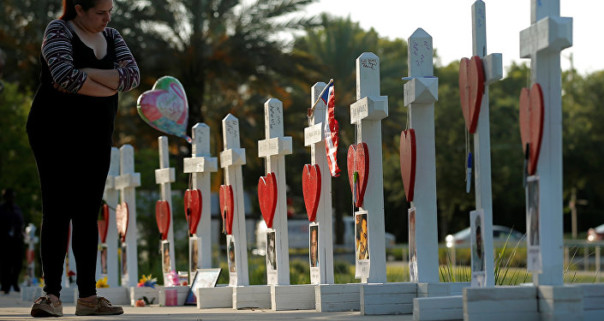 Женщина у мемориала в честь тех кто был убит в ночном клубе Pulse в Орландо штат Флорида США