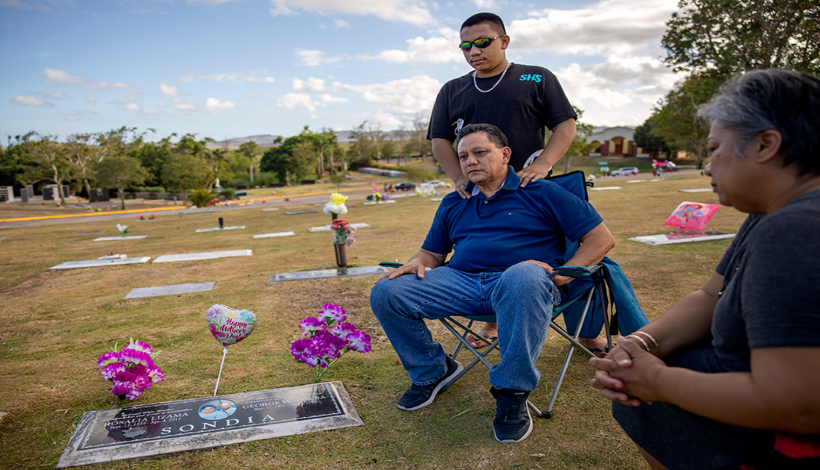 57-летний Роланд Сондиа вместе с сыном и женой на могиле матери. Она умерла до того, как он рассказал ей о произошедшем Фото: David Goldman / AP