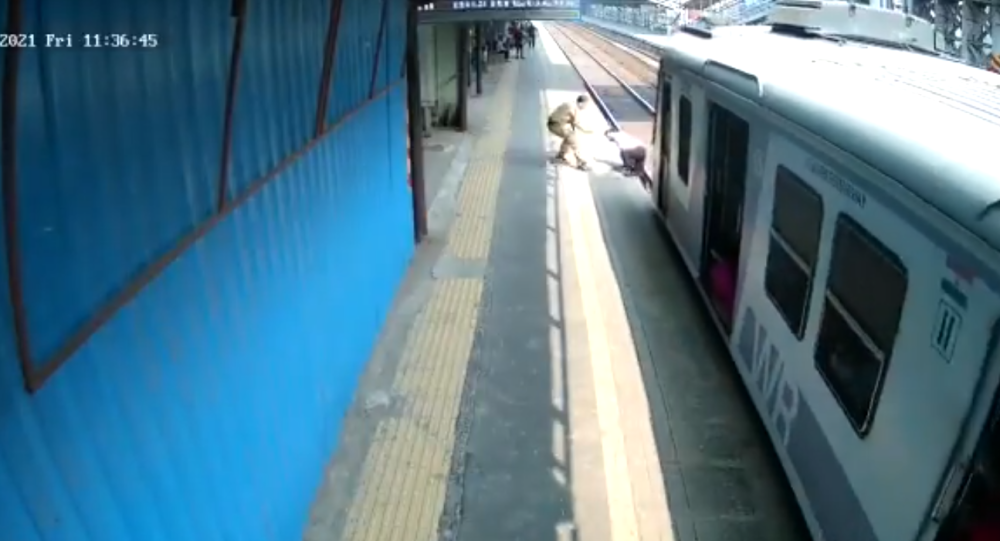 Посмотрите, как индийский полицейский ругает человека после того, как спас его от наезда поездом