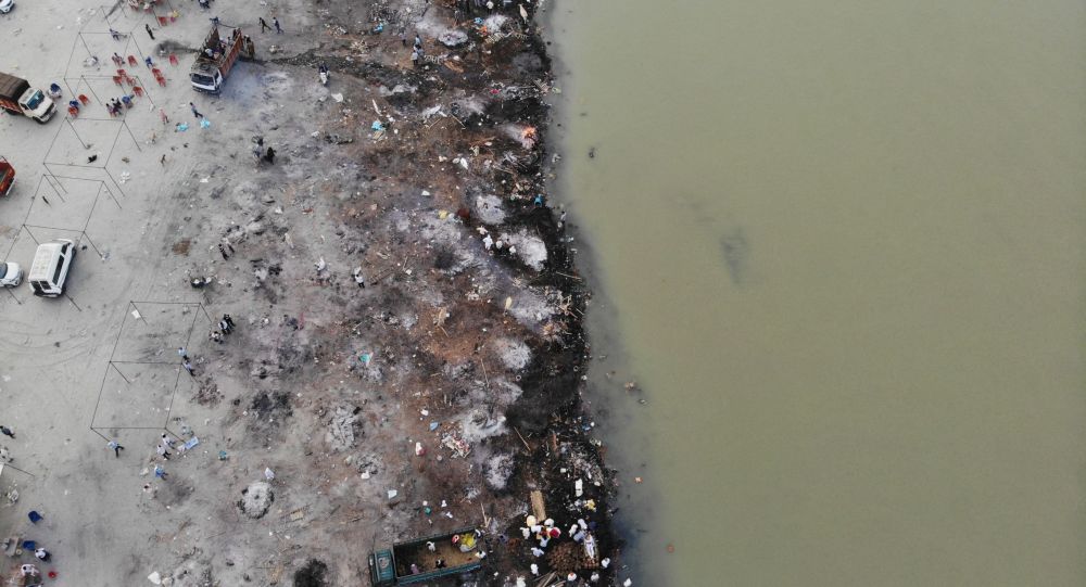 После вскрытия массового захоронения на берегу реки Ганг индийская полиция сжигает трупы с помощью шин и бензина