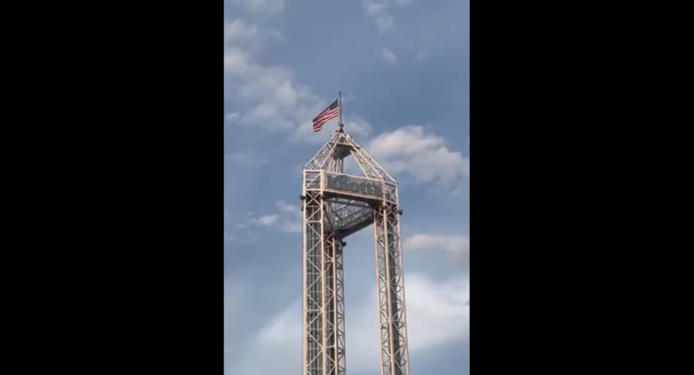 Сообщается, что человек, стоящий на вершине высокой башни на ферме Ноттс Берри в Калифорнии, отказывается спускаться